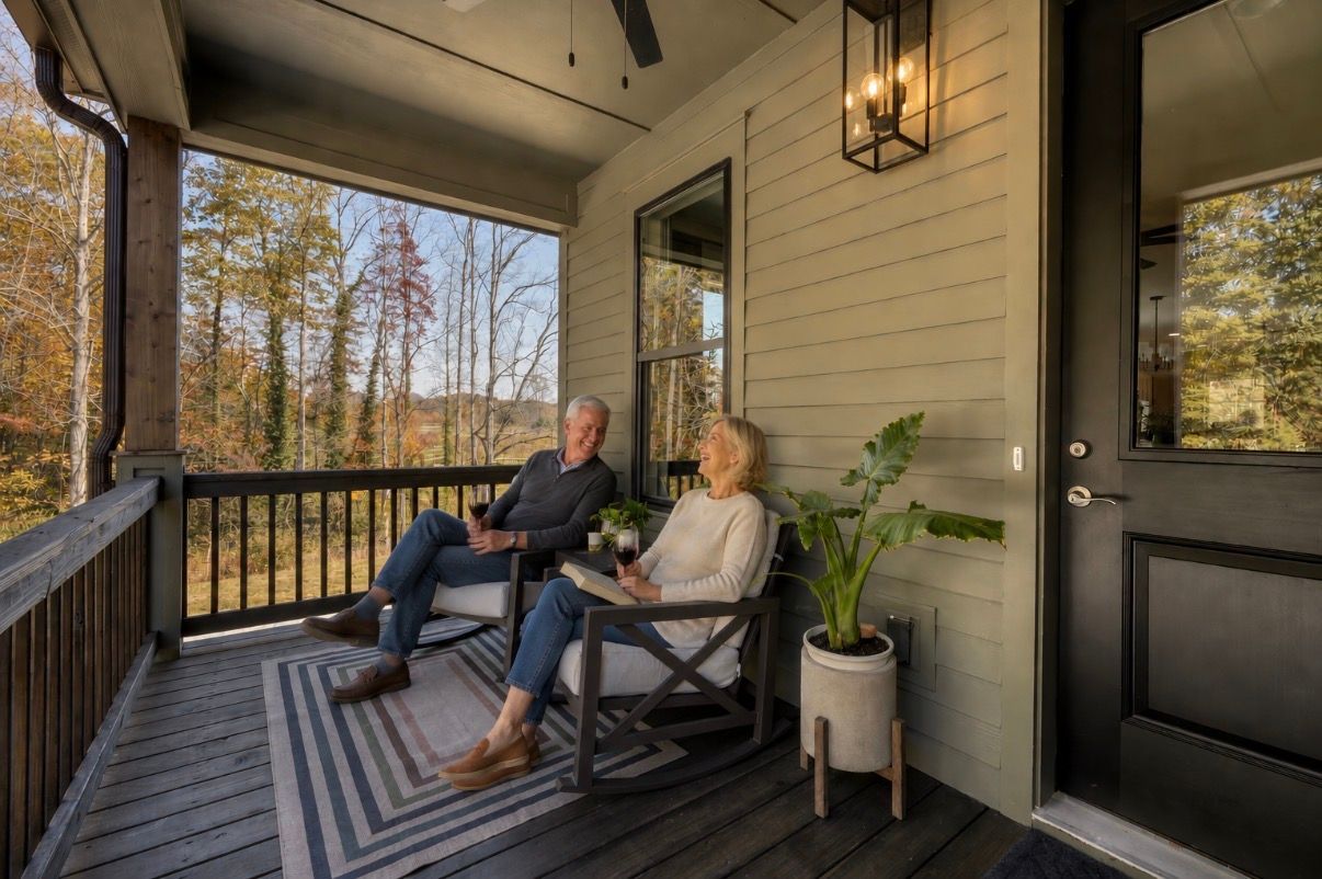 A happy couple sits on the front porch of The Retreats at Tiger Mountain