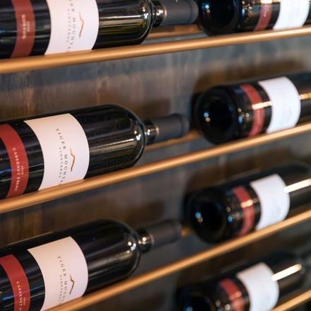 A row of wine bottles including a bottle of flora valley