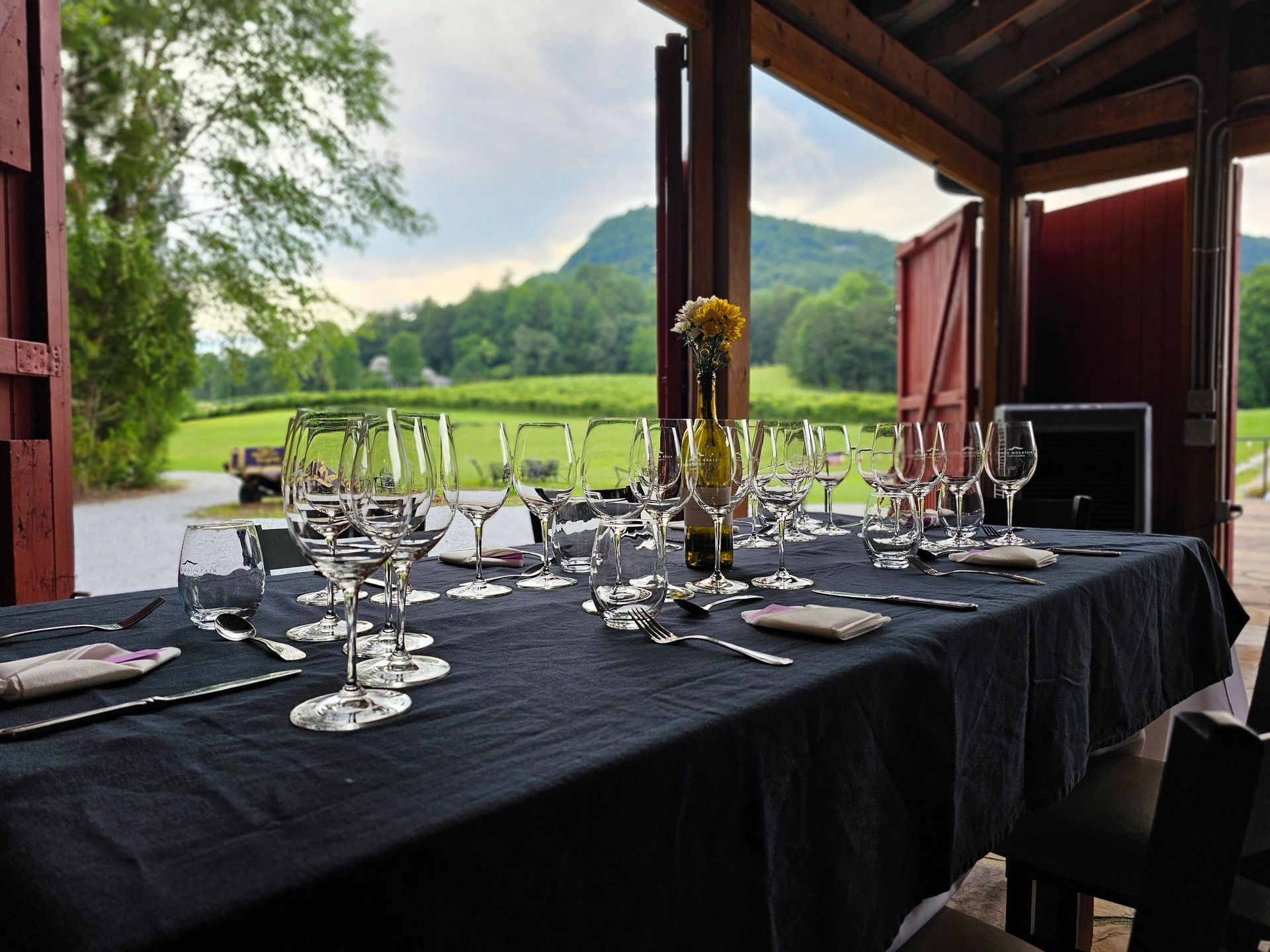 A table with a black tablecloth and wine glasses on it