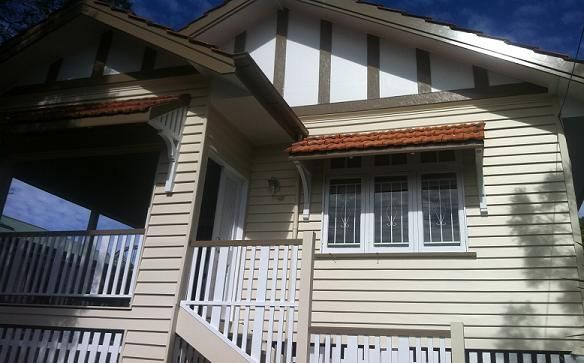 A white house with a balcony and stairs
