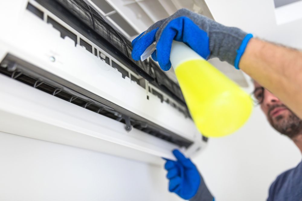 Professional Worker Fixing AC Unit — Air Conditioning Repairs in Vincentia NSW