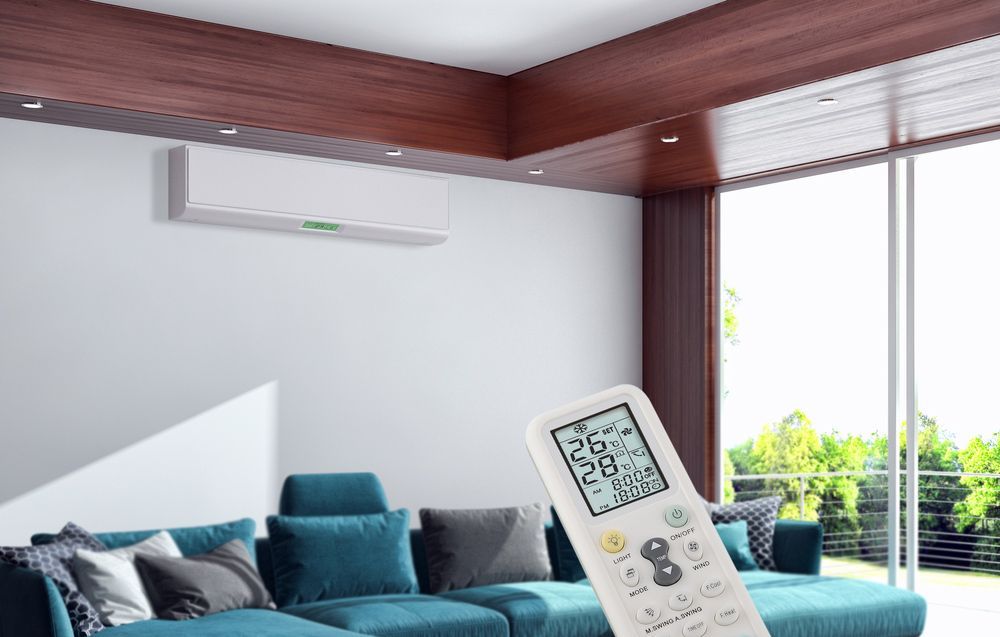 Holding a Remote of Air Conditioner to Change Temperature — Air Conditioning Repairs in Huskisson NSW
