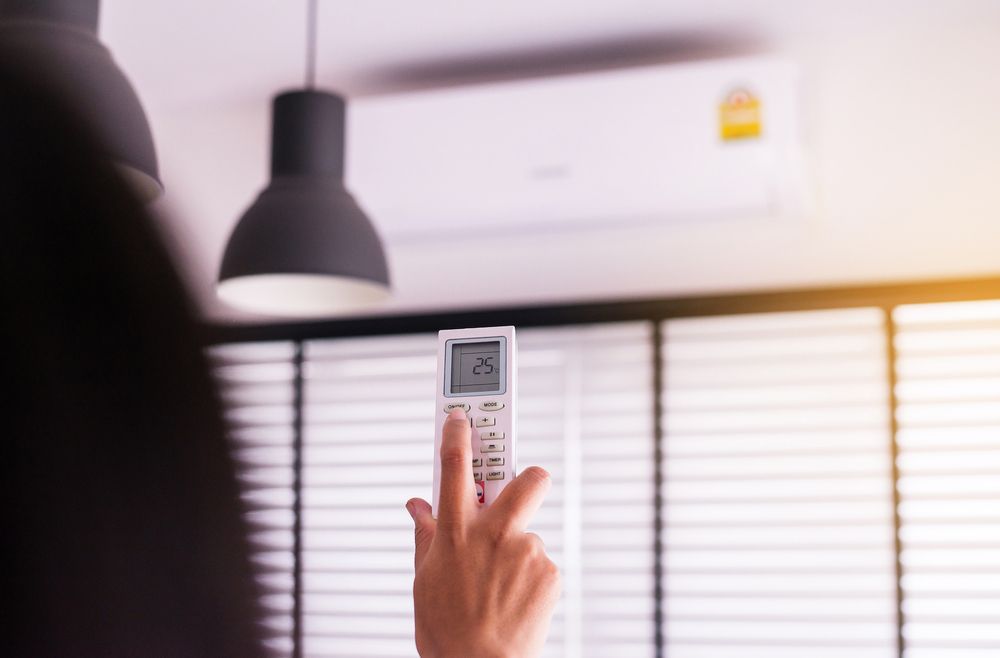 Person Using a Remote Control to Activating Air Conditioning — Air Conditioning Repairs in Ulladulla NSW
