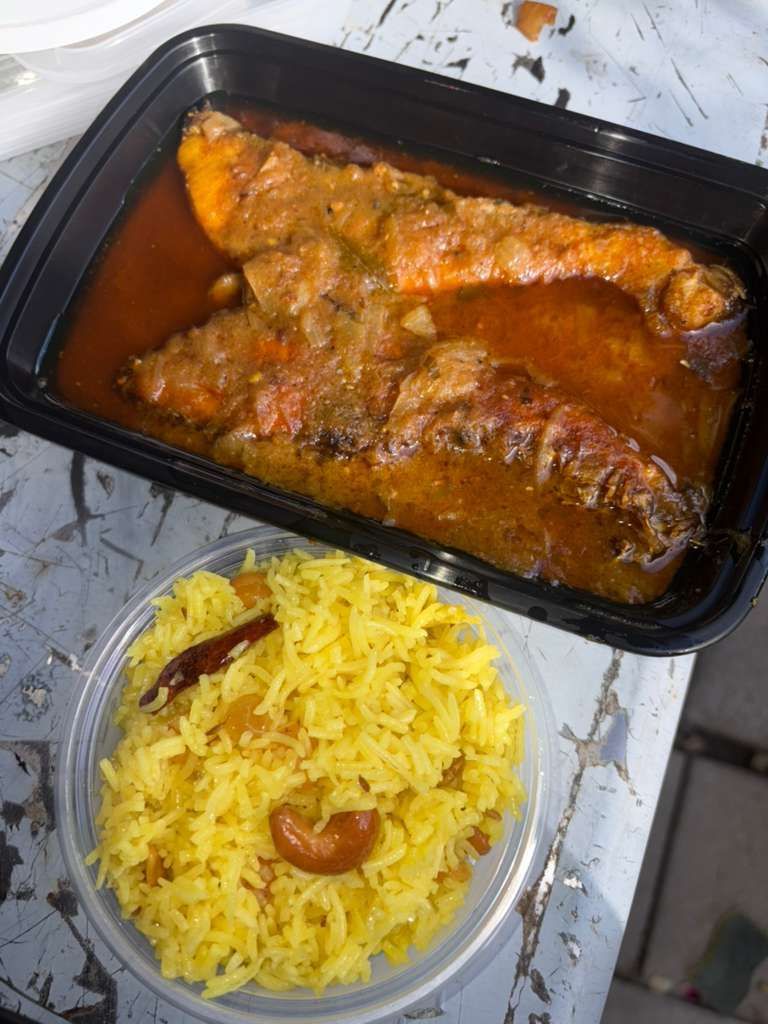 Takeout chicken curry with yellow rice in plastic containers