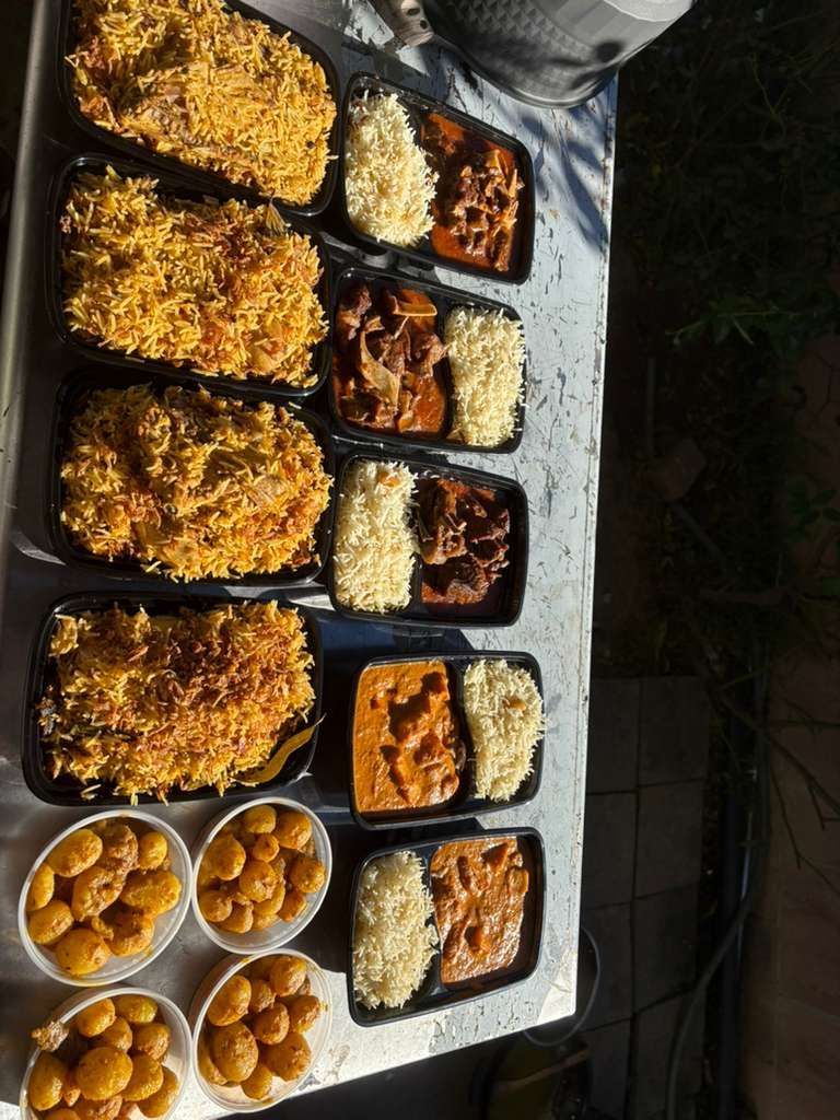 Assorted baked dishes and bowls of fried snacks arranged on a table outdoors.