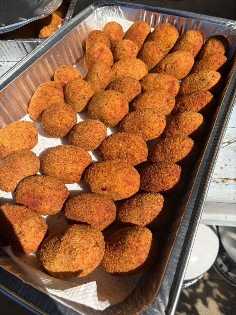 Tray of breaded fried snacks arranged in rows on a metal pan