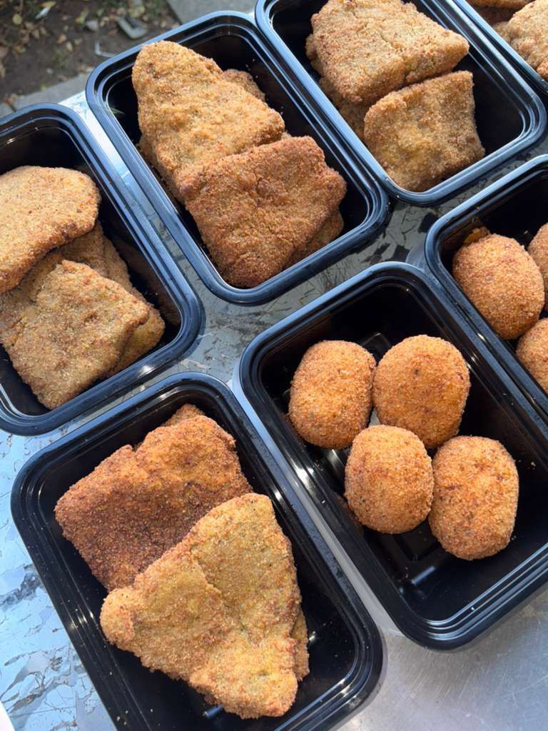 Takeout trays filled with breaded fried foods, including triangular cutlets and croquettes