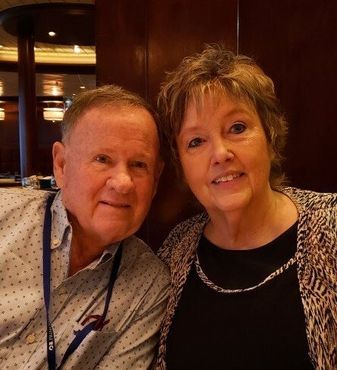 Two people smiling together in a warmly lit restaurant booth.