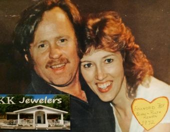 Smiling couple posing in front of KK Jewelers storefront, with a heart-shaped note in the foreground
