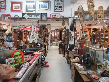 Old Man's Junk shop filled with furniture, collectibles, and decor items, with a central aisle.