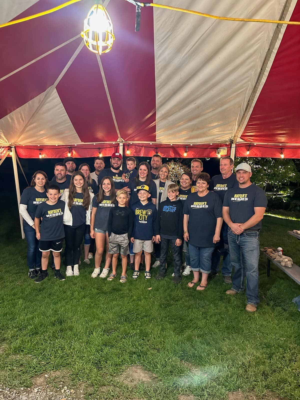 A group of people are posing for a picture under a tent.