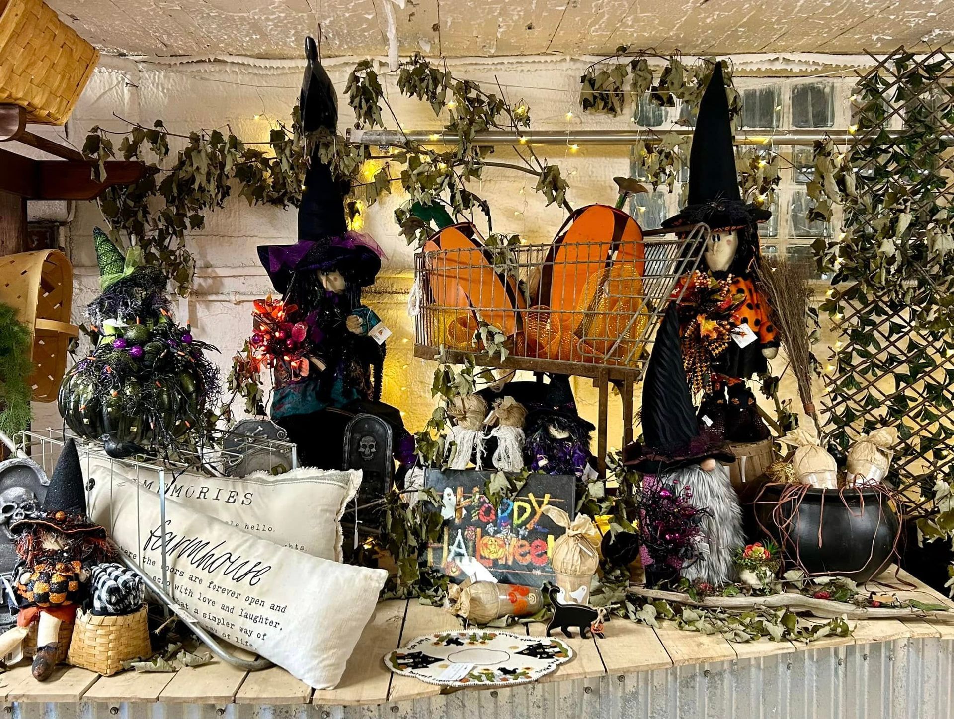 A display of halloween decorations and witches on a table.