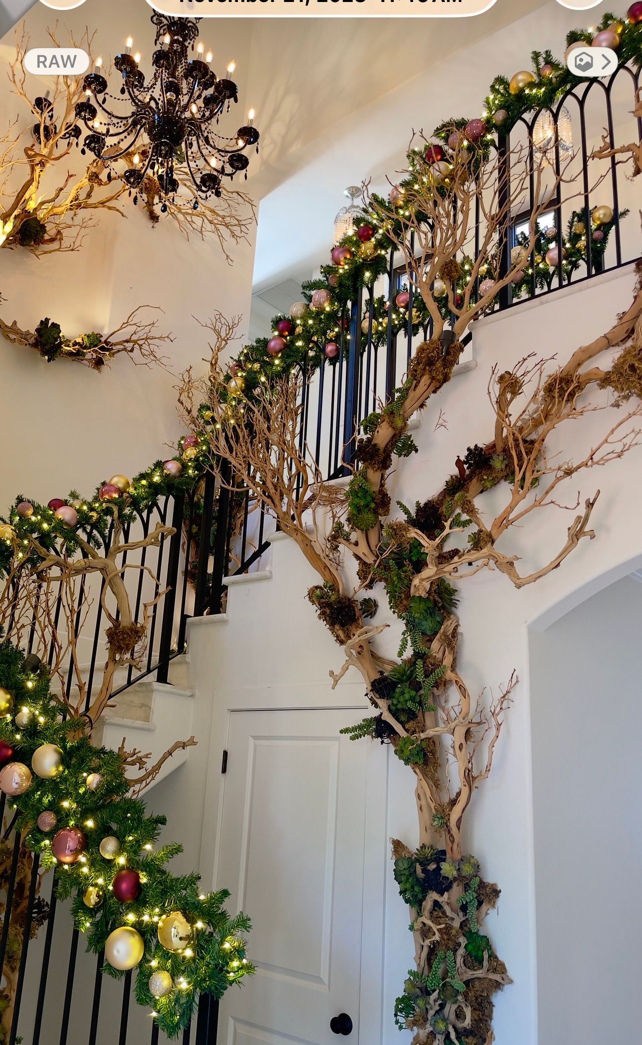 Flower-covered staircase railing in a home with white walls and a closed door below