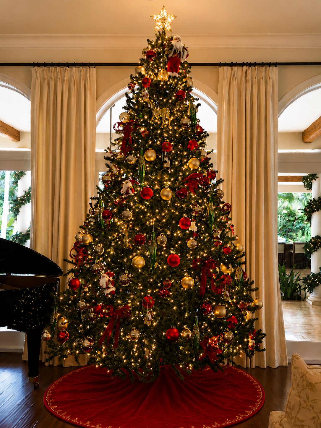 Decorated Christmas tree with red ornaments and lights in a room with large windows and curtains