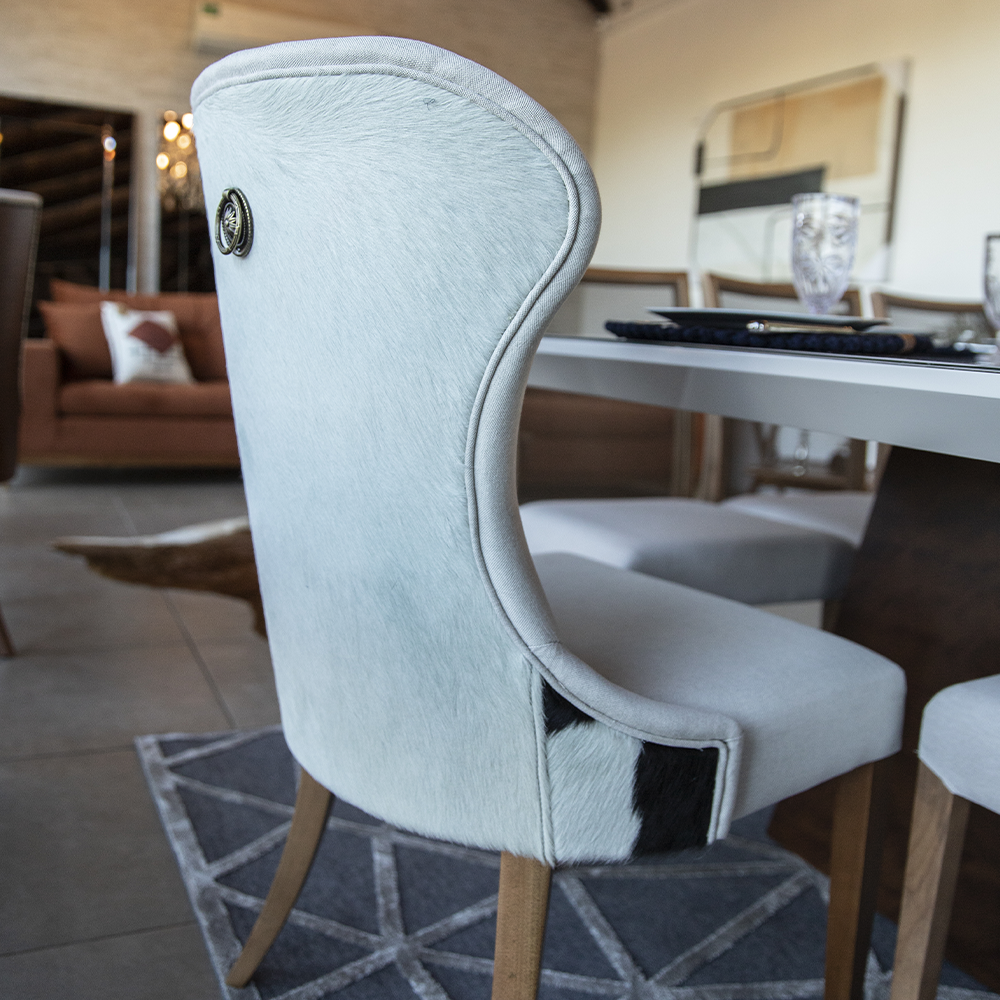 Uma cadeira branca está sentada em frente a uma mesa em uma sala de estar