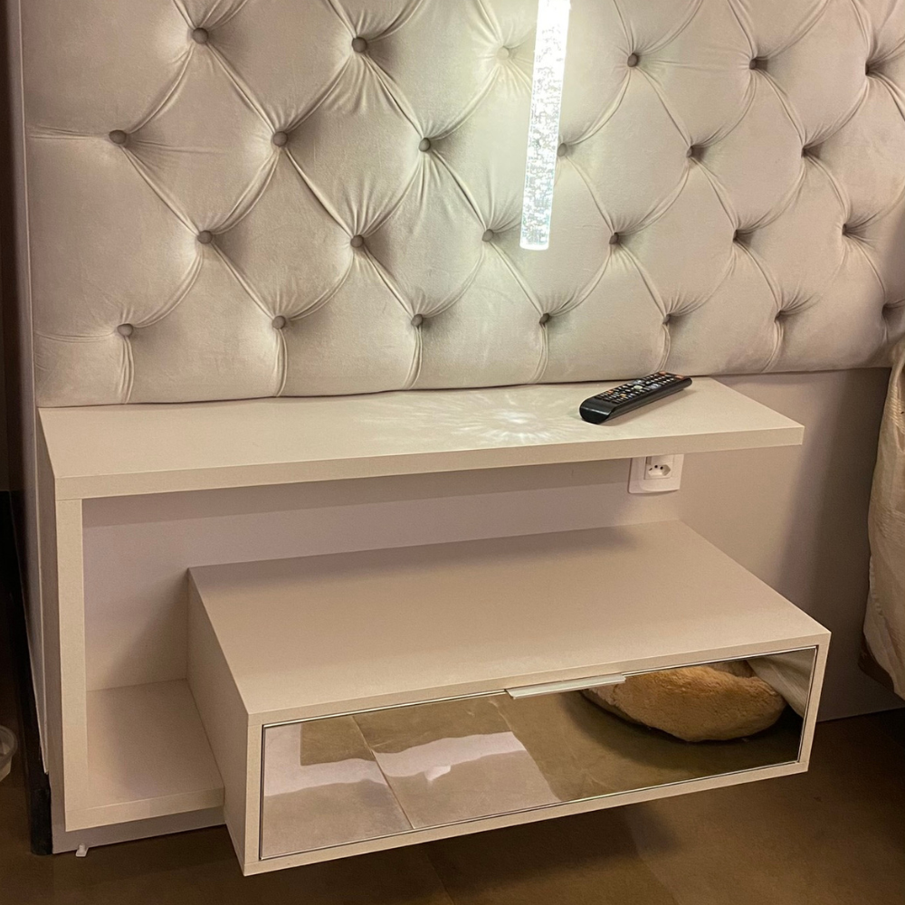 Um quarto com cama, mesa de cabeceira, candeeiro e portas de correr.