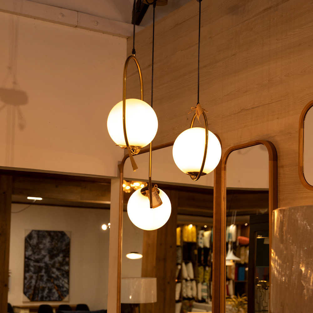 Uma sala com dois espelhos e três luzes penduradas no teto