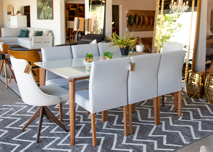 Uma mesa e cadeiras de sala de jantar estão sobre um tapete em uma sala de estar.