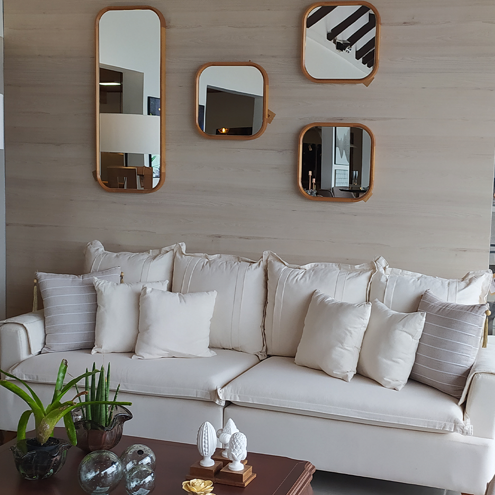 Uma sala com sofá branco e espelhos na parede