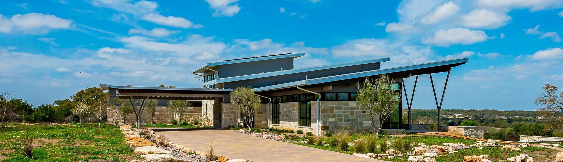 Modern house with angled metal roof on a sunny day.