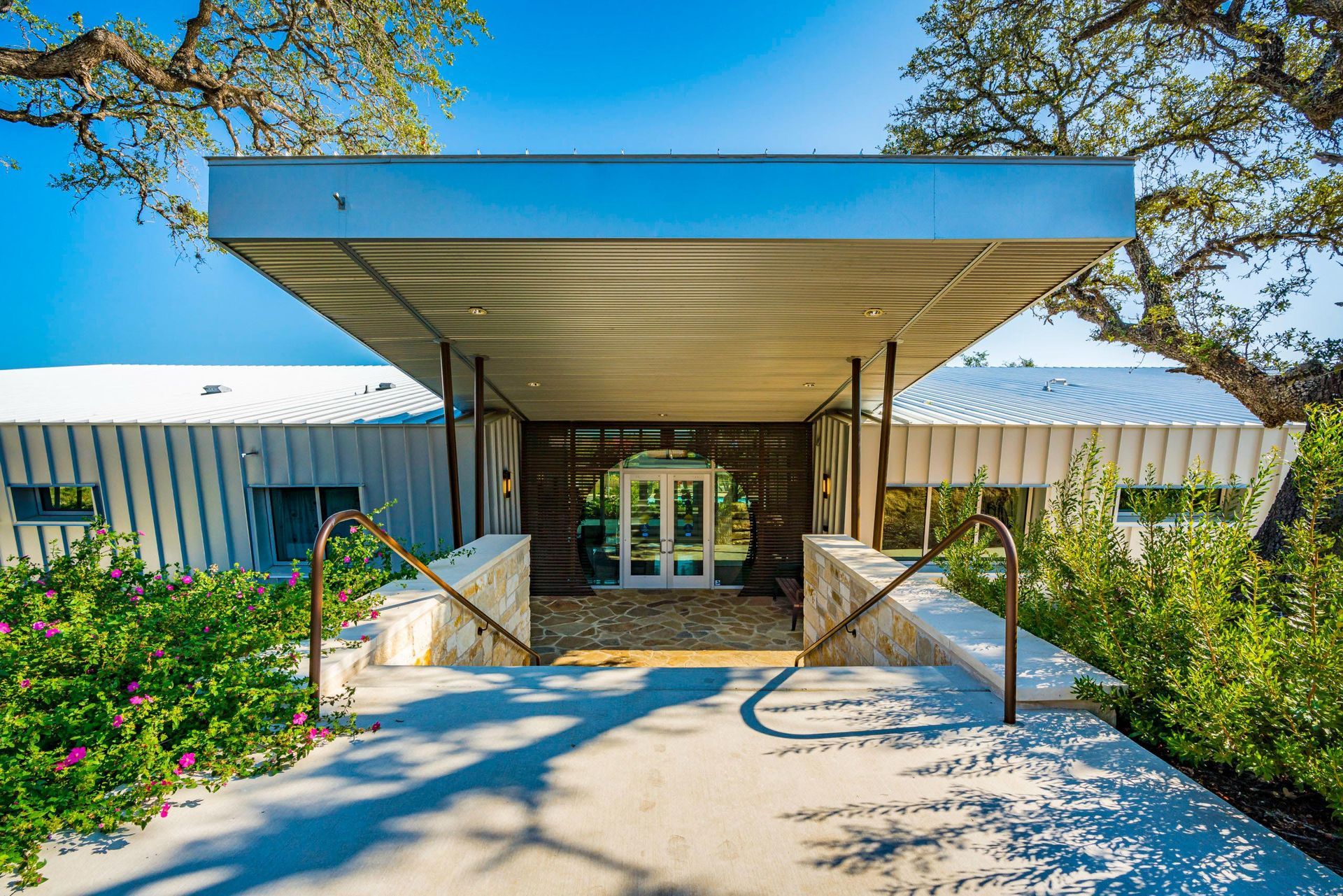 Modern home entrance with a long covered walkway and front door.