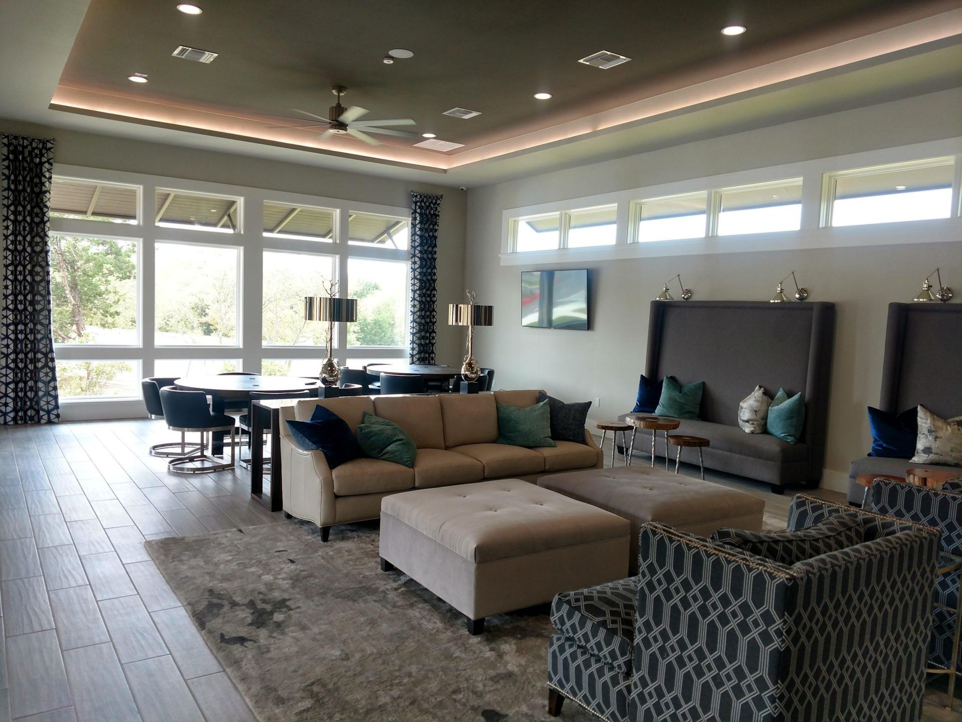 Lounge area with seating, tables, large windows, and decorative lighting.