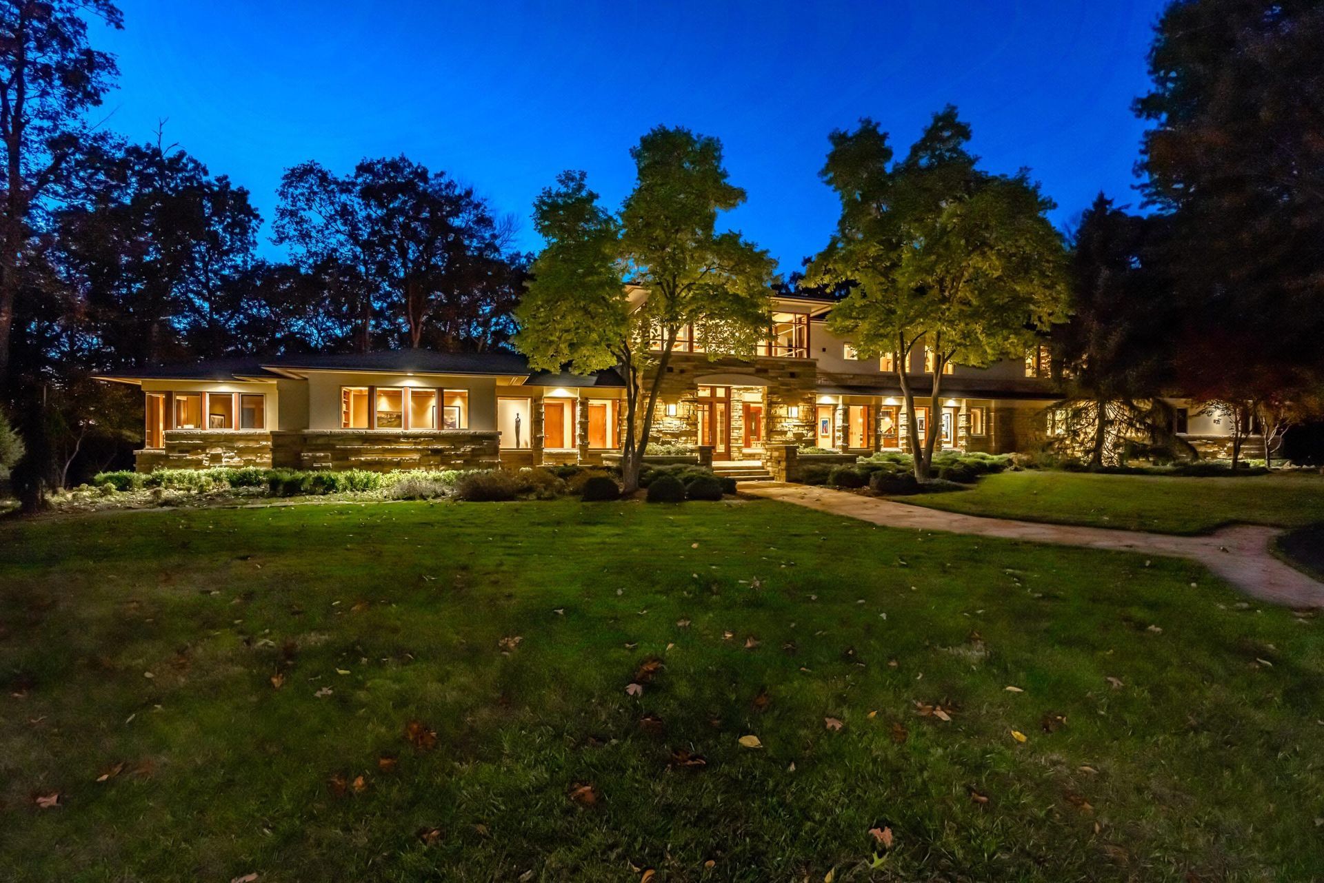 A large house with lots of windows is lit up at night