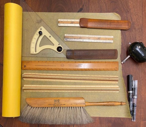 A yellow roll of paper with a ruler and brush on it
