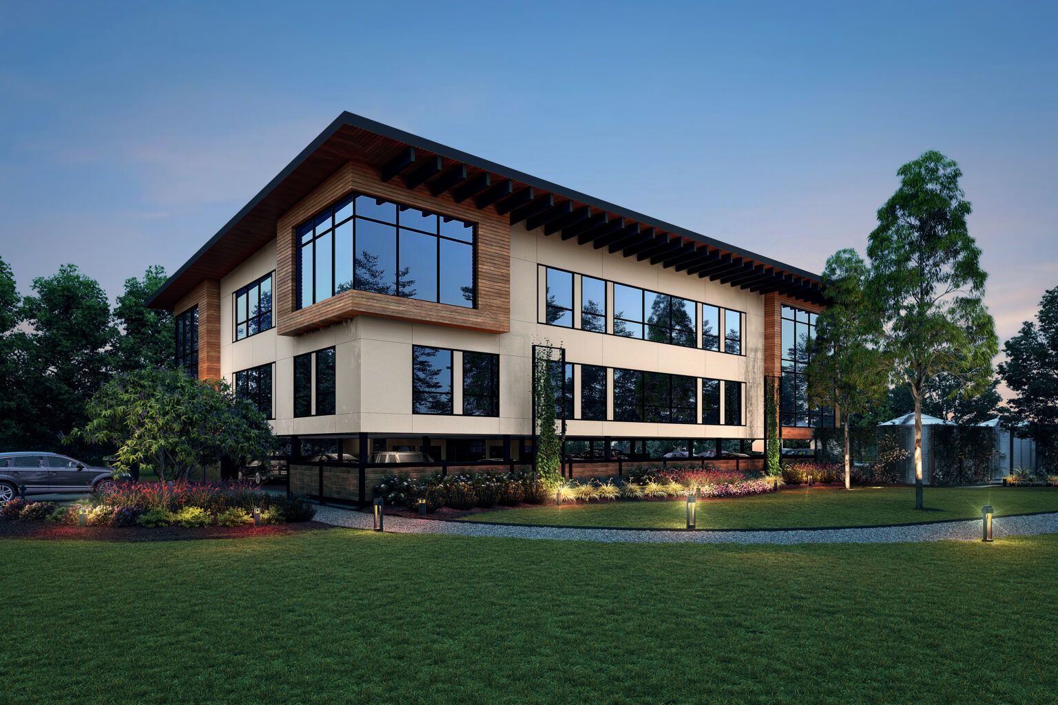 A large building with a lot of windows is surrounded by trees and grass.