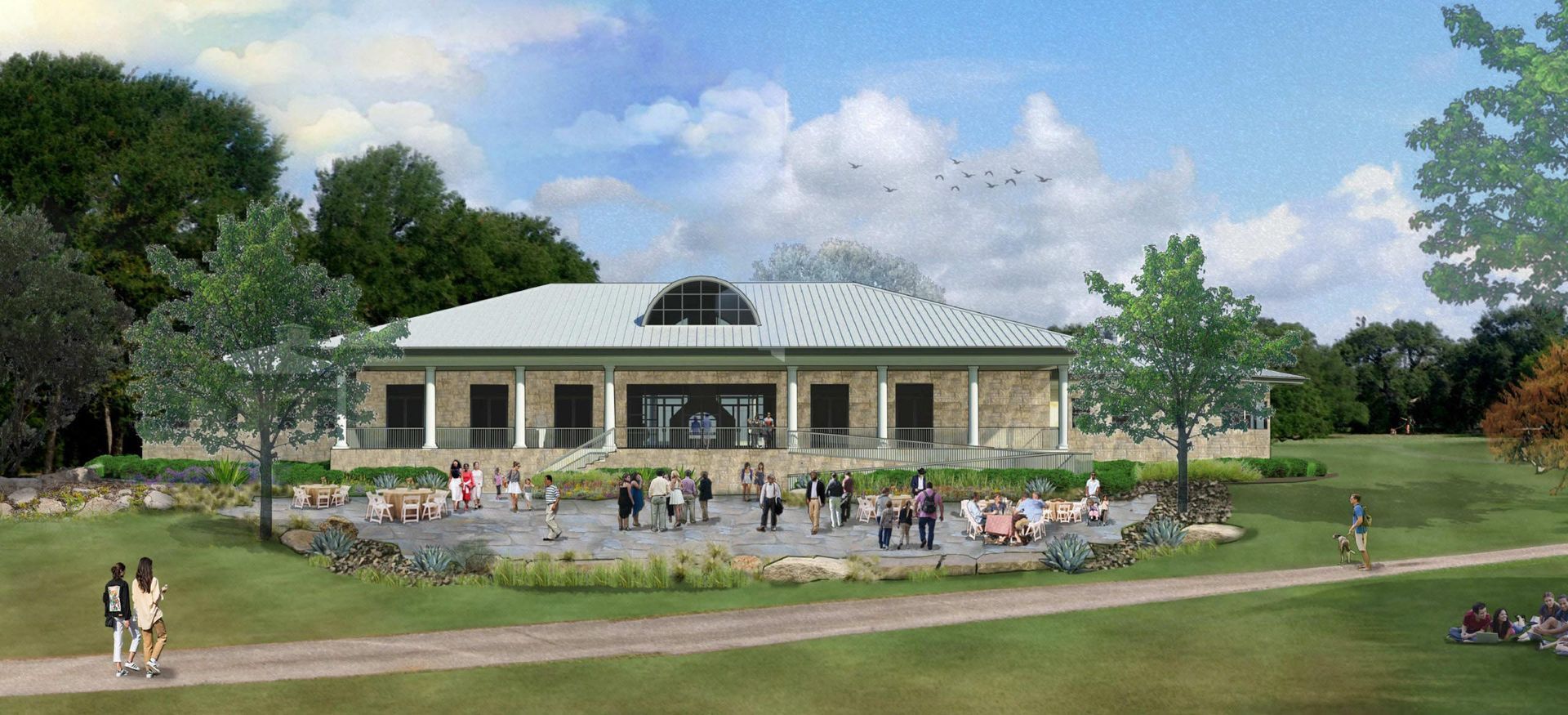 A building with columns, people on a patio, trees, and a grassy lawn under a blue sky.
