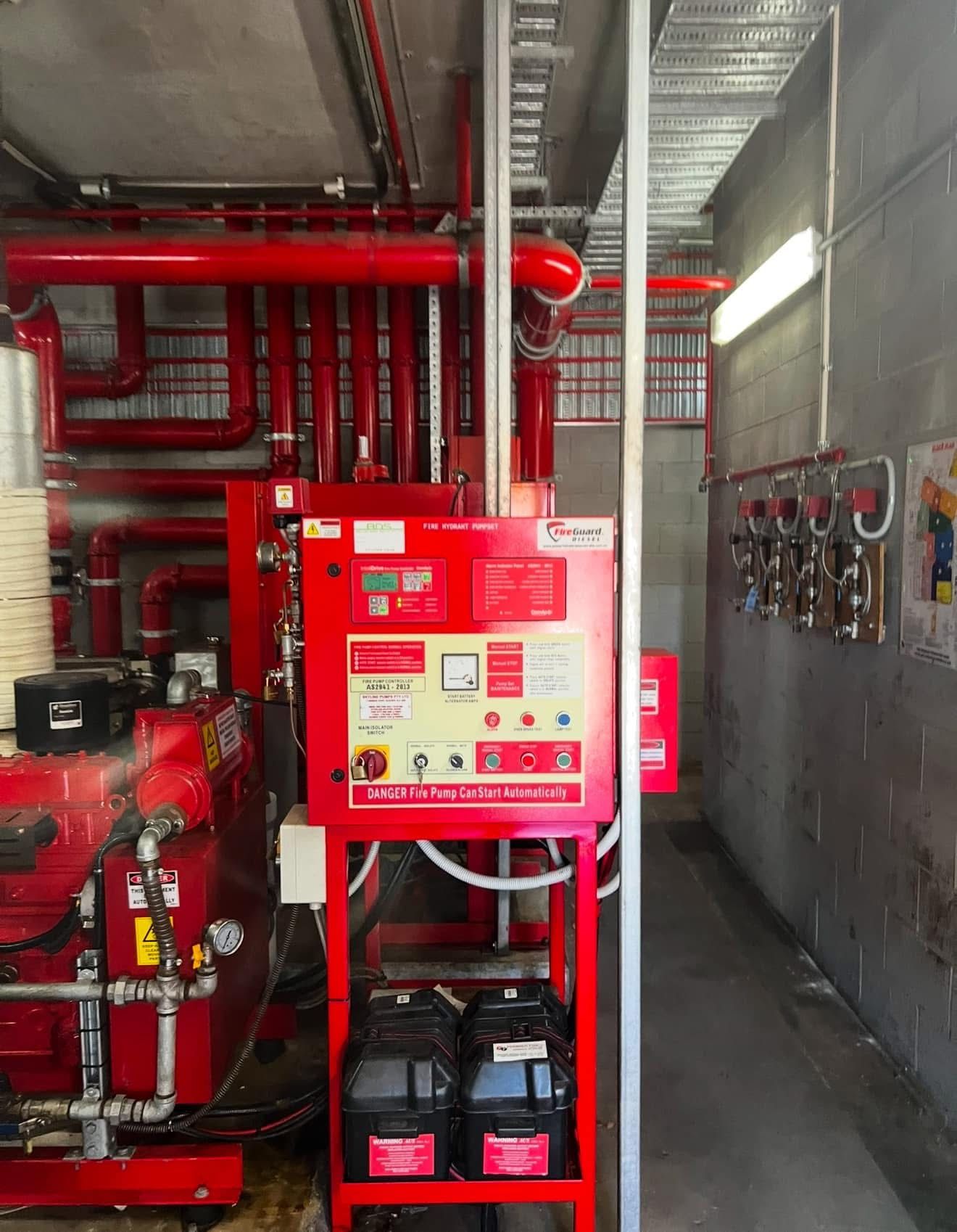 Red Fire Suppression Control Panel in an Industrial Room With Pipes and Equipment — Flaming North Fire Protection Pty Ltd in Garbutt, QLD