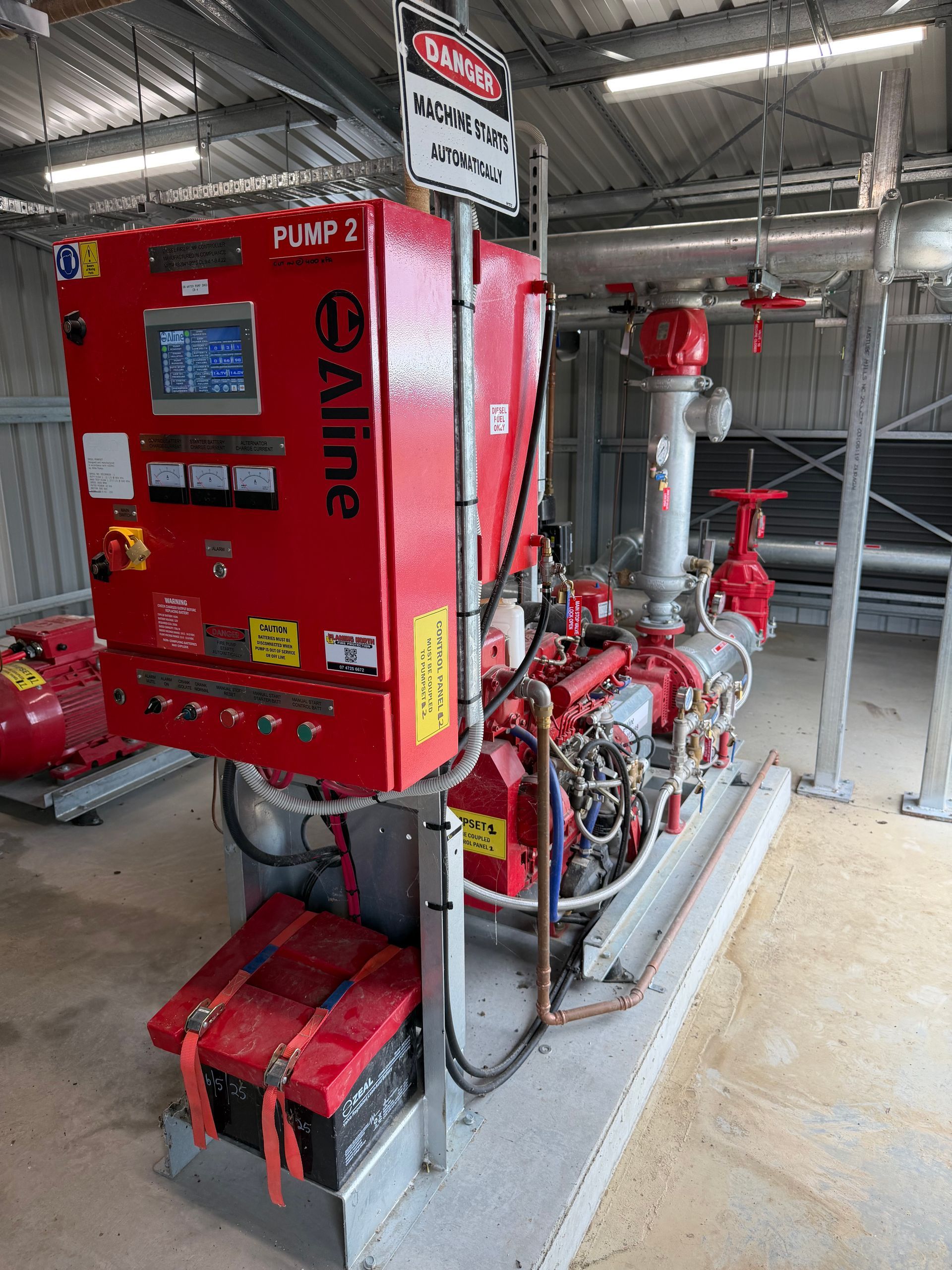 Red Industrial Pump System With a Red Control Cabinet in a Utility Room — Flaming North Fire Protection Pty Ltd in Garbutt, QLD