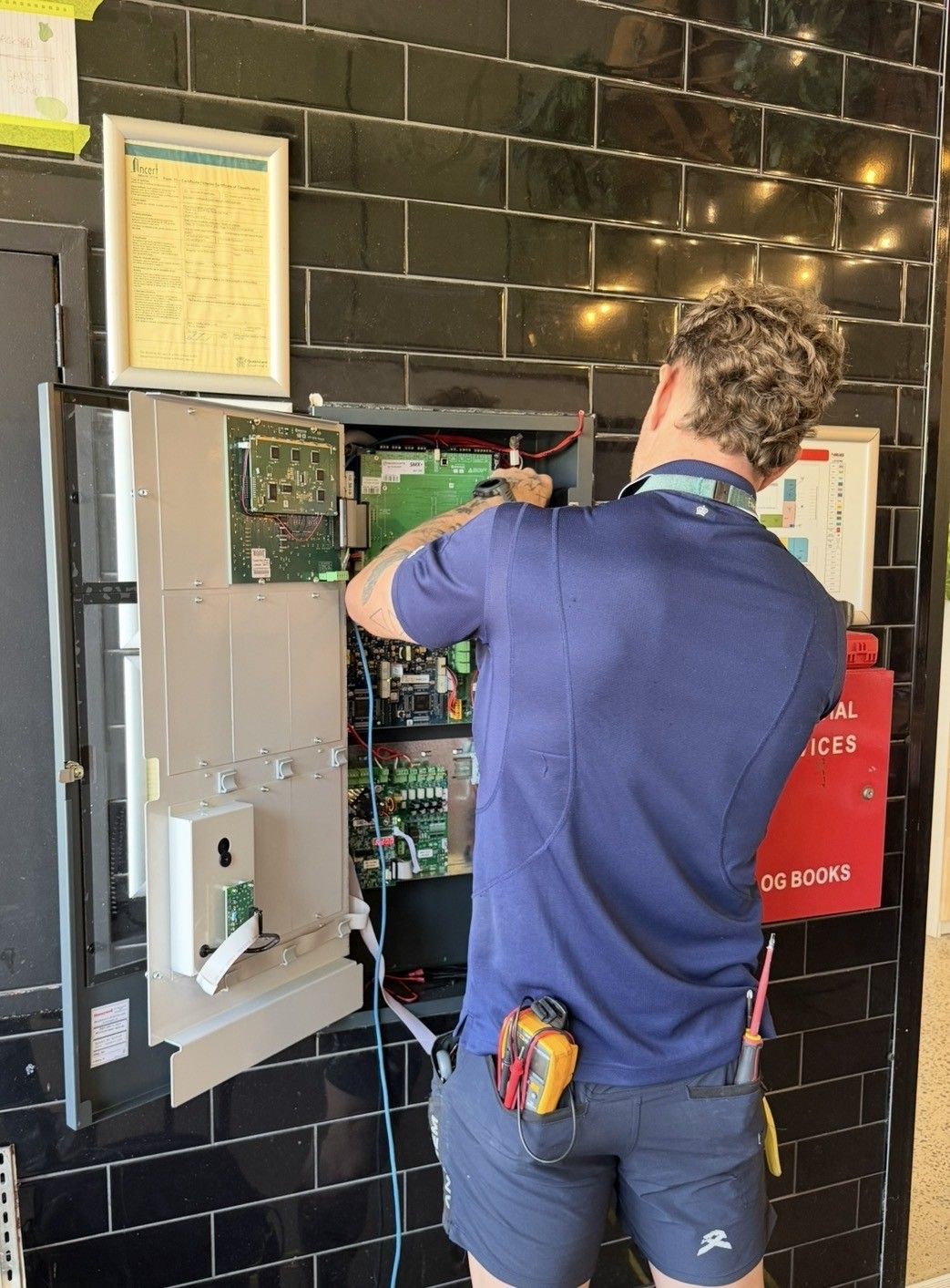 Worker Using a Fire Extinguisher Beside a Doorway in a Lobby Area — Flaming North Fire Protection Pty Ltd in Garbutt, QLD