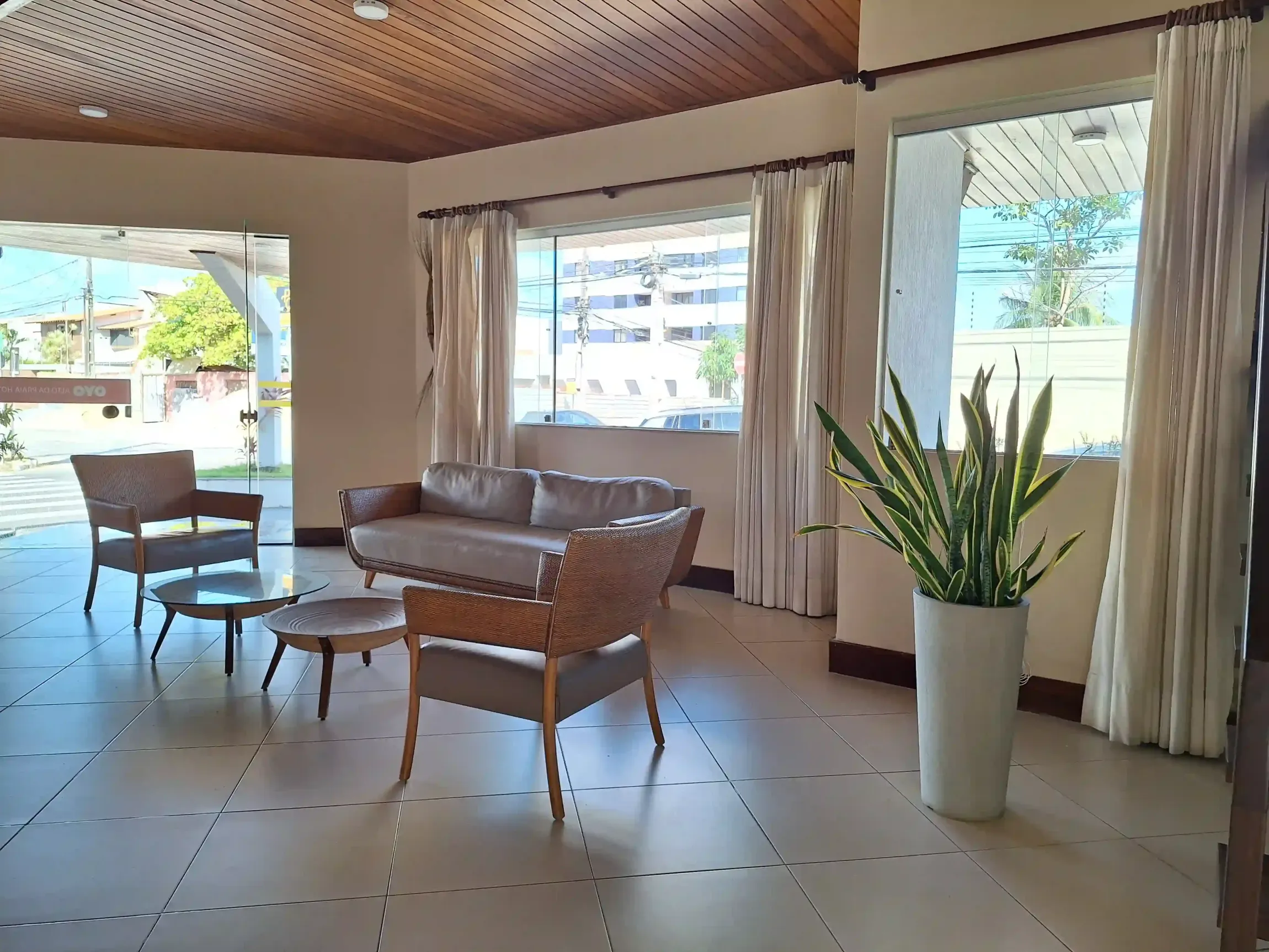 Uma sala de estar com um sofá, cadeiras, uma mesa e uma planta - Alto-da-Praia-Hotel