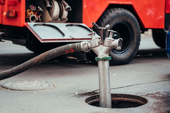 Fire truck connected to a fire hydrant in a city street.