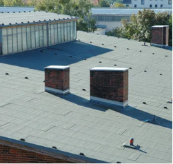 There are two chimneys on the roof of a building.