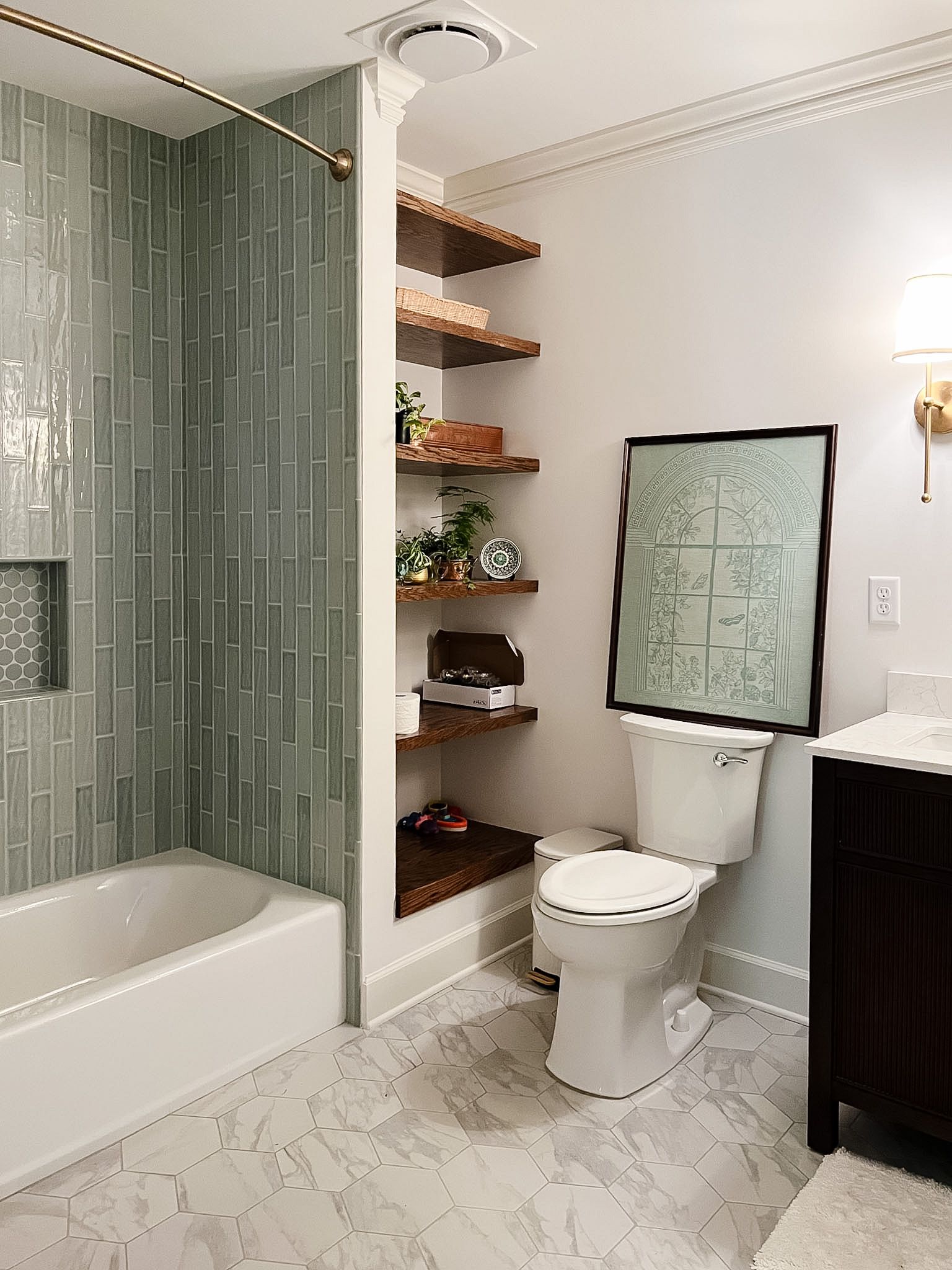 Bathroom with a bathtub, toilet, open shelves, and a patterned shower curtain in light gray tones