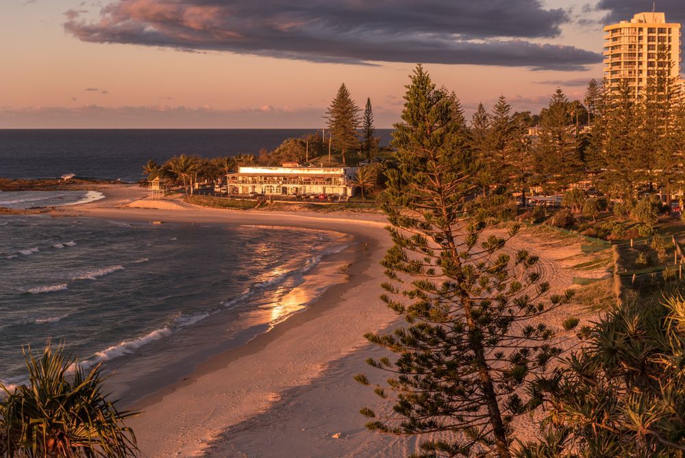 Beach at Sunset With Ocean, Sand, Trees, and Buildings — Landscape Supplies in Gold Coast, QLD