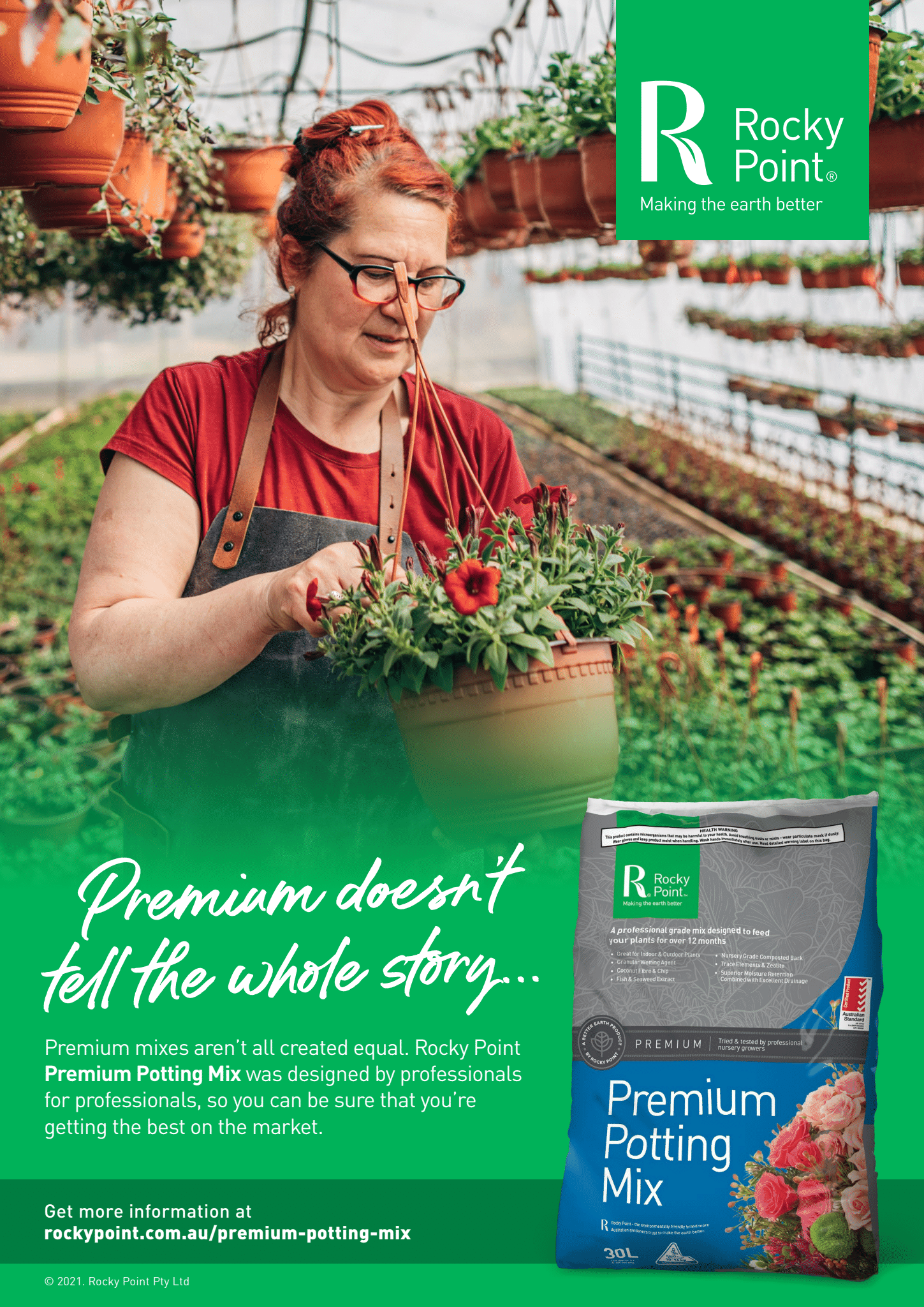 Gardener in Red Shirt Holding a Flower in A Greenhouse Beside Premium Potting Mix Bag — Tweed Landscape Supplies in Tweed Heads, NSW