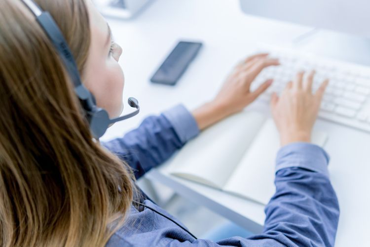 A woman working in customer service at her computer.