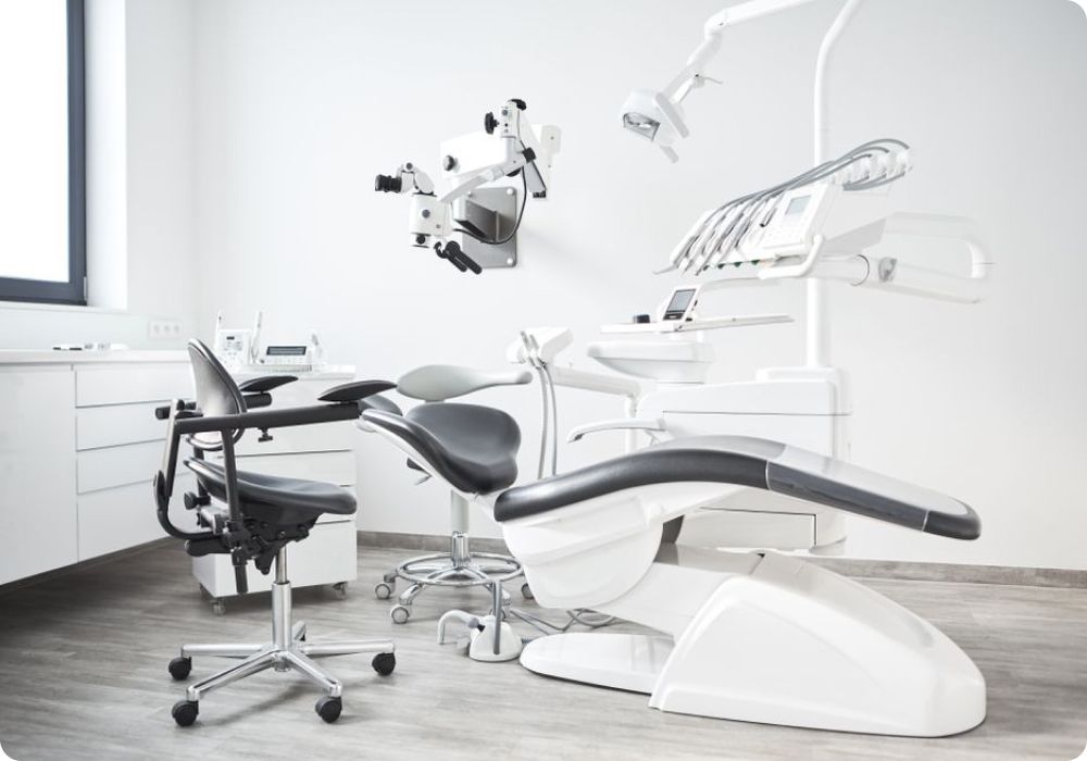 A dental office with a dental chair and microscope.