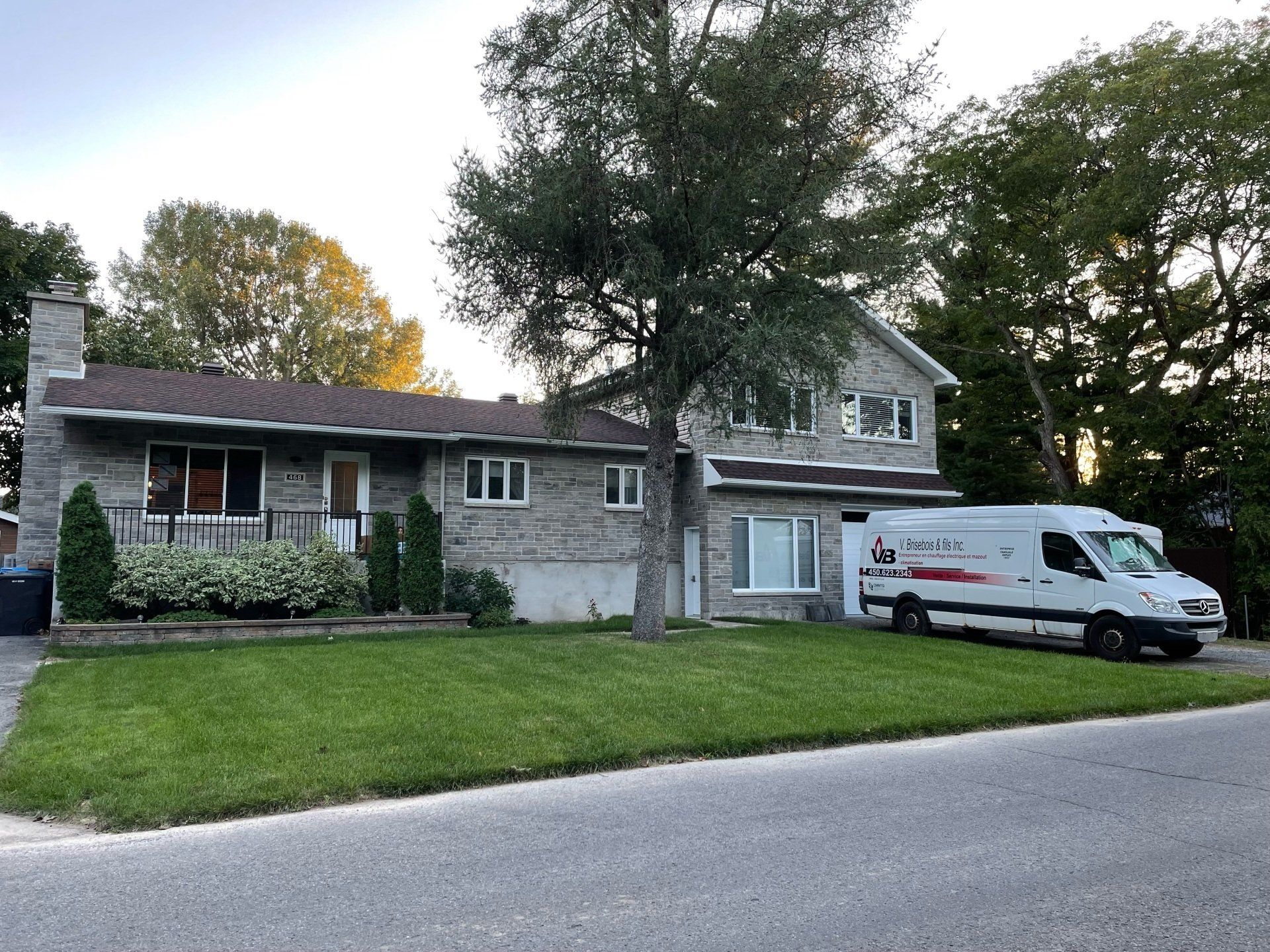 Une camionnette blanche est garée devant une maison