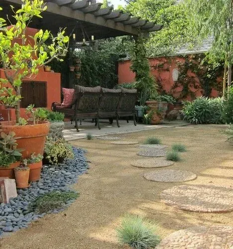 A patio with a couch and chairs under a pergola