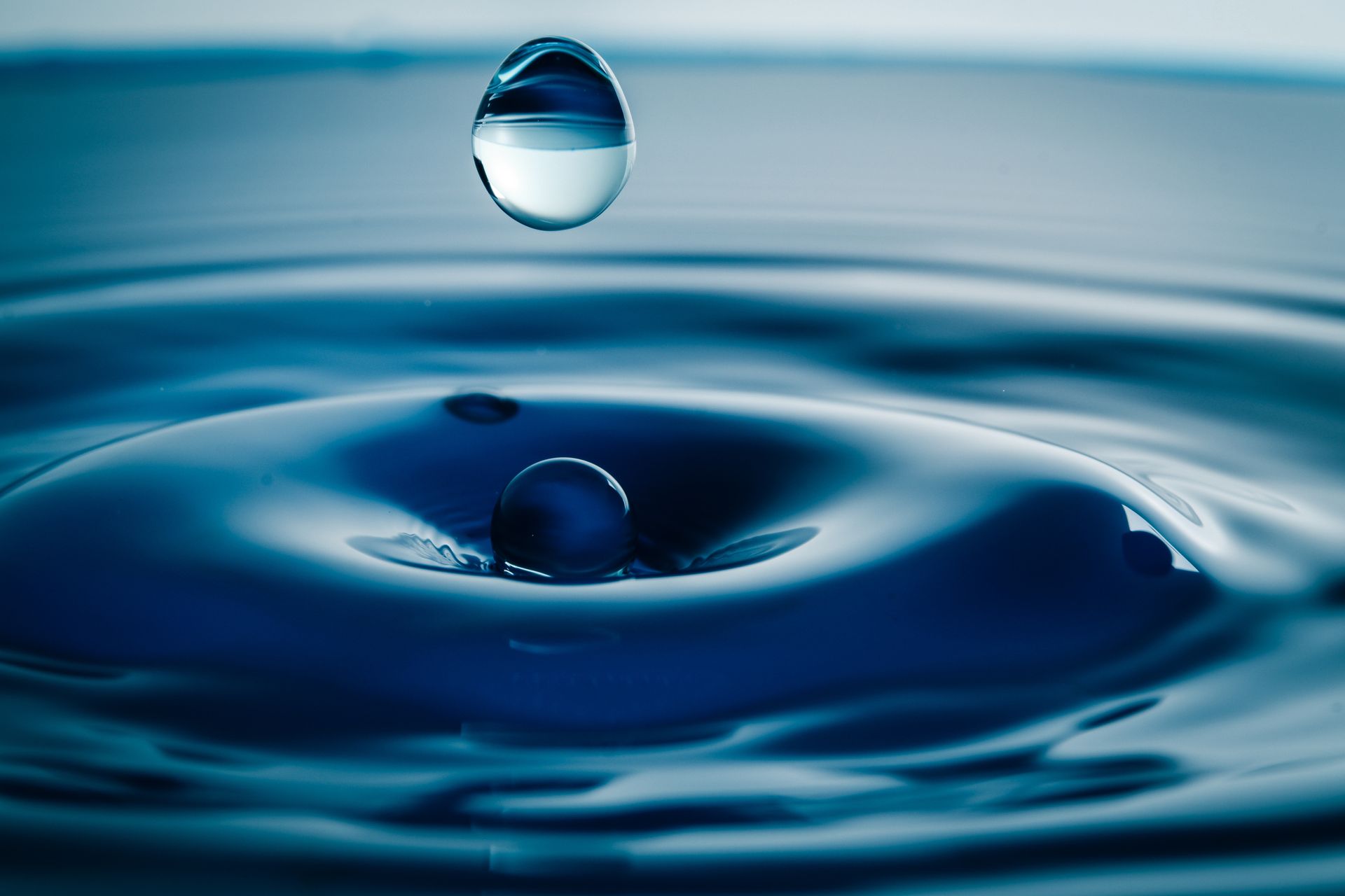 A drop of water is falling into a pool of water.