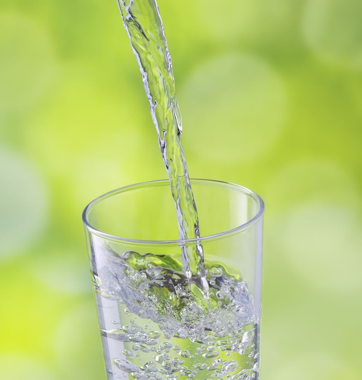 A glass of water is being poured into a glass.