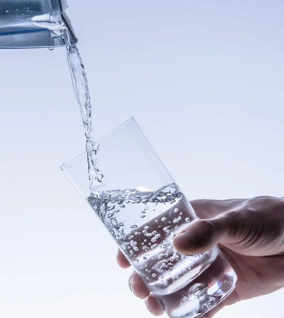 A person is pouring water into a glass