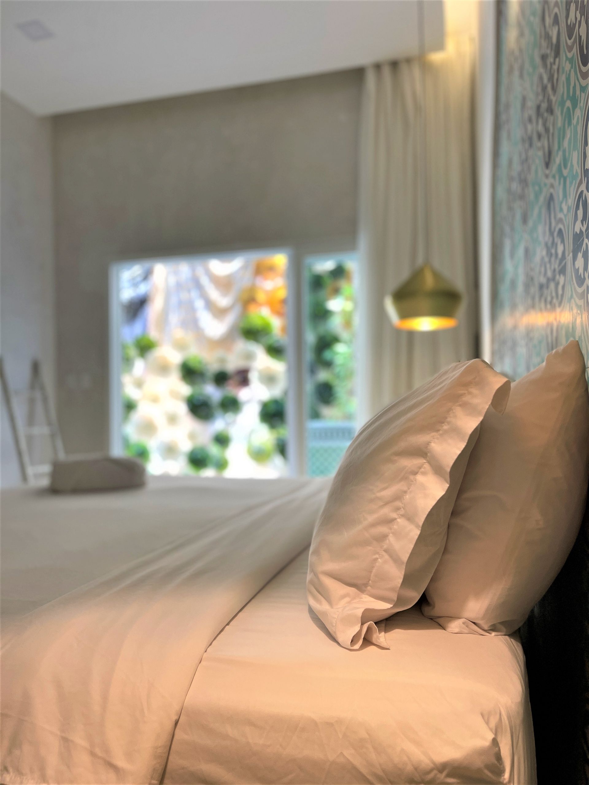 A bed with white sheets and pillows in a hotel room