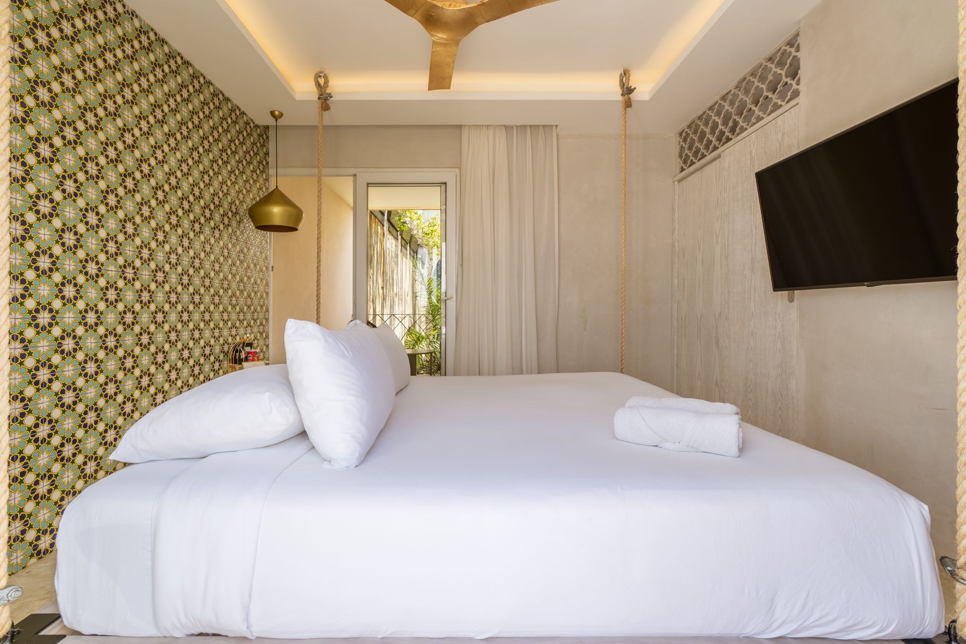 A bedroom with a king size bed , television , and ceiling fan.