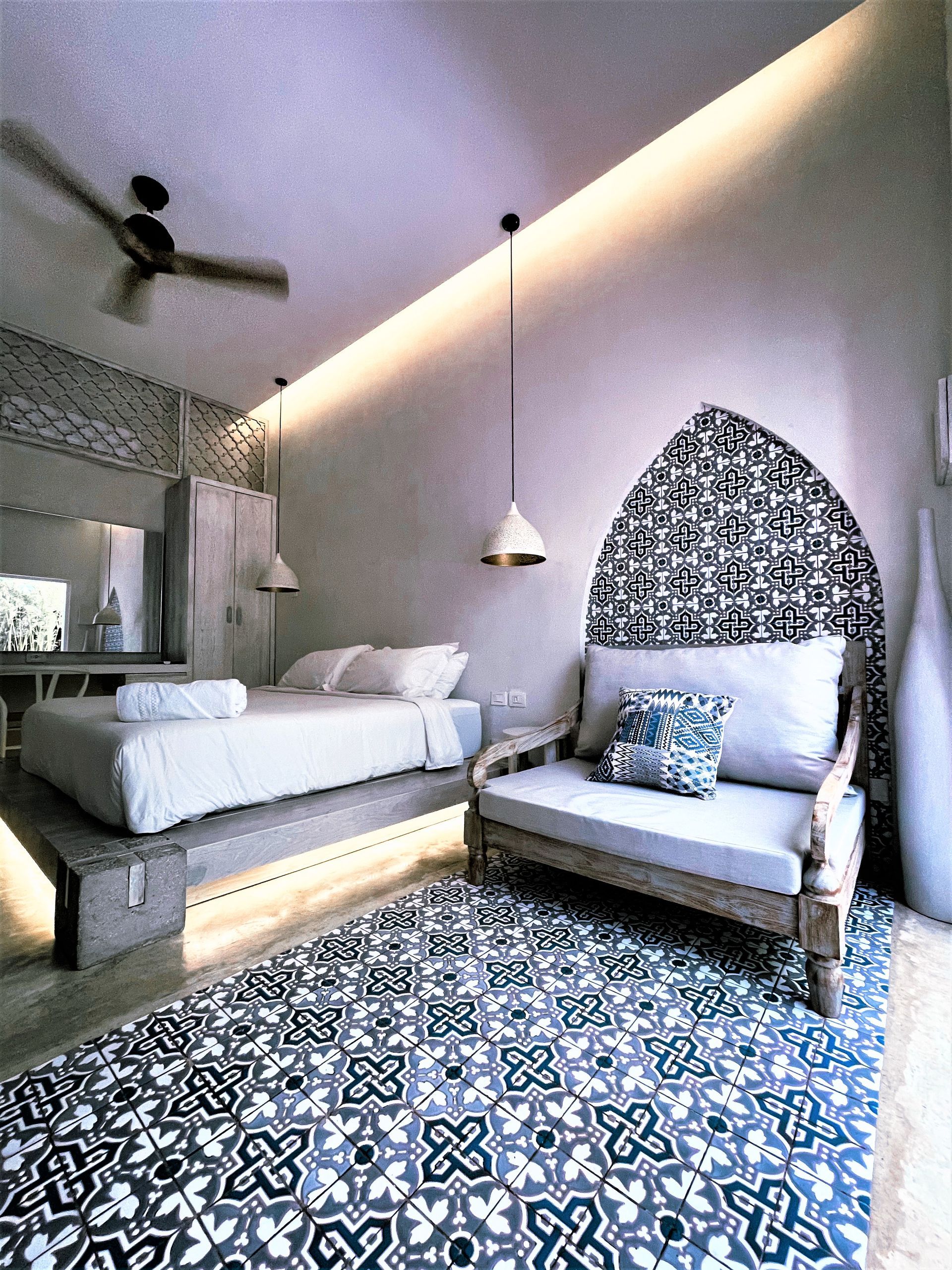 A bedroom with a bed , chair , and ceiling fan.