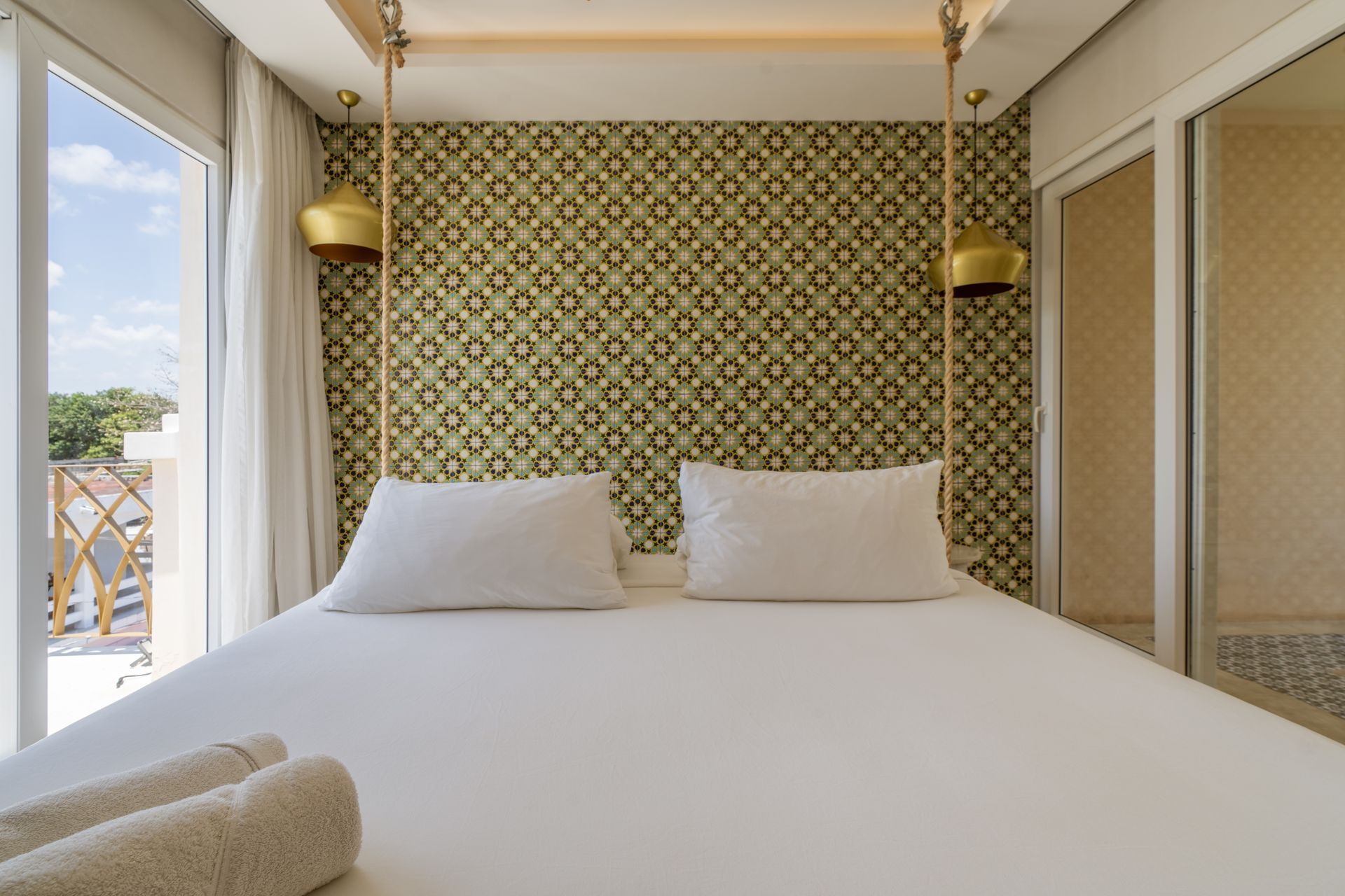 A bedroom with a king size bed and a large window.